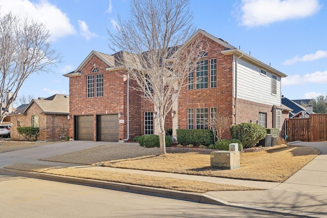 traditional-style house featuring a garage, central AC, brick siding, fence, and concrete driveway