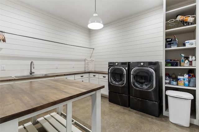 5949 County Road 137, Flint, TX 75762 - clothes washing area featuring washing machine and clothes dryer, wood walls, and cabinet space