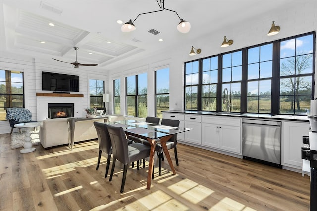 5949 County Road 137, Flint, TX 75762 - dining space featuring coffered ceiling, a glass covered fireplace, light wood finished floors, recessed lighting, and beamed ceiling