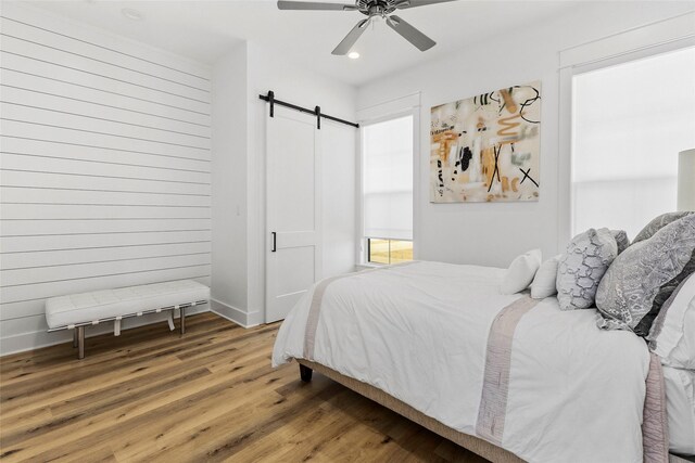 5949 County Road 137, Flint, TX 75762 - bedroom featuring a barn door, wood finished floors, baseboards, recessed lighting, and ceiling fan