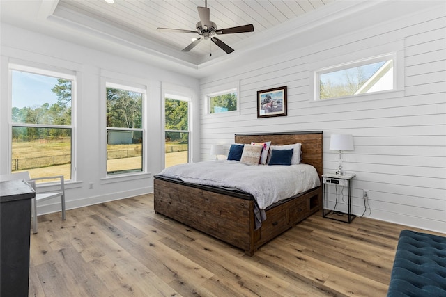 5949 County Road 137, Flint, TX 75762 - bedroom featuring a raised ceiling, multiple windows, light wood-style floors, wood ceiling, and wood walls