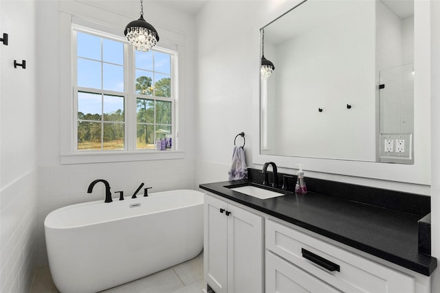 5949 County Road 137, Flint, TX 75762 - full bathroom featuring a chandelier, a freestanding tub, vanity, tile walls, and tile patterned flooring