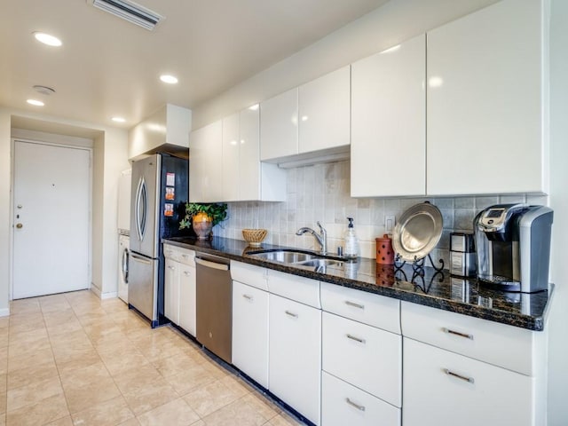 3525 Turtle Creek Blvd Unit 3D, Dallas, TX 75219 - kitchen with appliances with stainless steel finishes, white cabinets, dark stone counters, decorative backsplash, and a sink