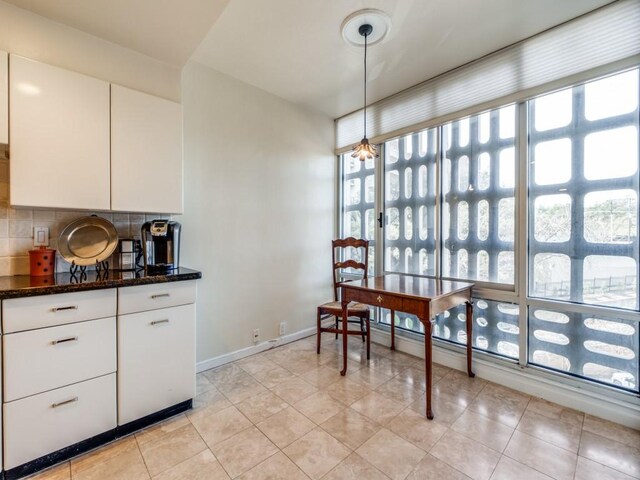 3525 Turtle Creek Blvd Unit 3D, Dallas, TX 75219 - kitchen with plenty of natural light, tasteful backsplash, dark stone counters, and white cabinetry