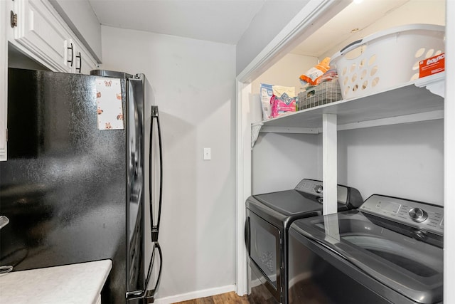 laundry area with independent washer and dryer, baseboards, and wood finished floors