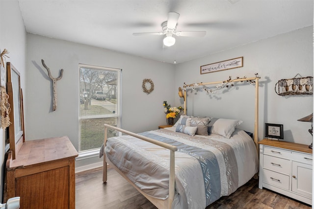 bedroom with dark wood-style floors, ceiling fan, and baseboards