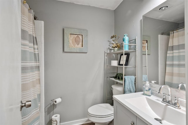 bathroom featuring a shower with curtain, baseboards, vanity, and toilet