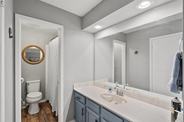 full bath with toilet, wood finished floors, vanity, and recessed lighting