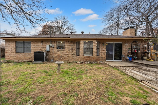 back of house with central AC, a yard, brick siding, and a patio