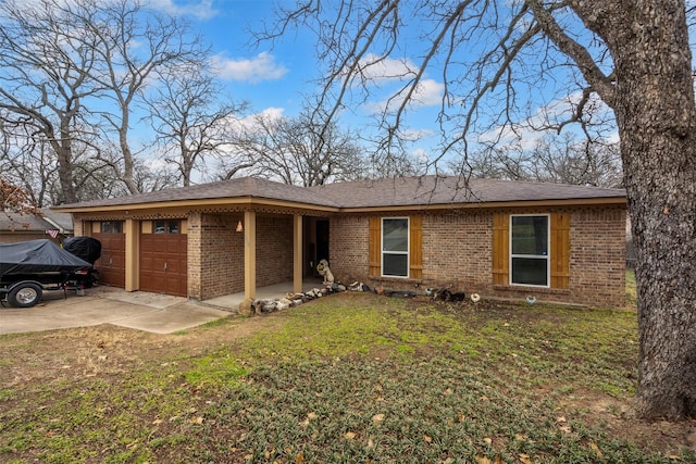 ranch-style house featuring driveway, brick siding, a front lawn, and an attached garage