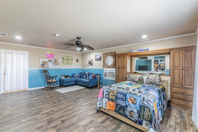 bedroom with a wainscoted wall, wood finished floors, attic access, and crown molding