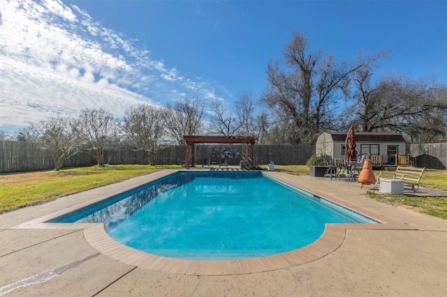 view of pool featuring an outbuilding, a patio, a storage structure, and a fenced backyard