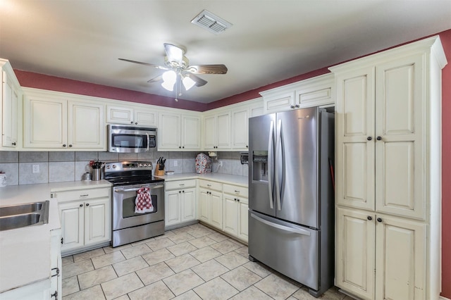 kitchen with visible vents, a ceiling fan, appliances with stainless steel finishes, light countertops, and backsplash