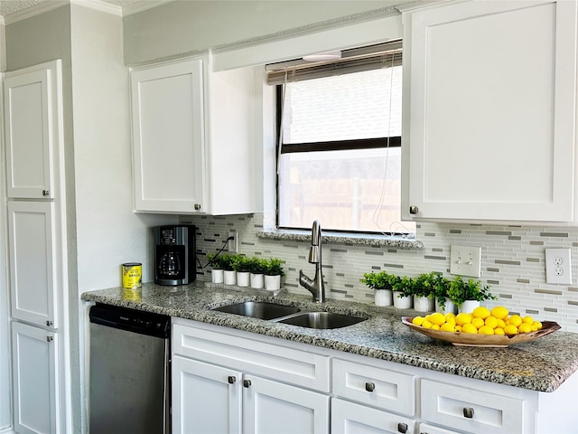 kitchen featuring tasteful backsplash, white cabinets, dishwasher, and a sink