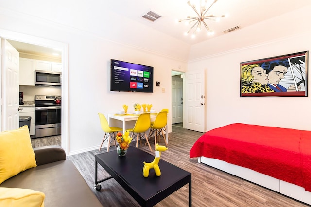 bedroom featuring baseboards, wood finished floors, visible vents, and a notable chandelier