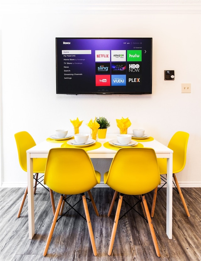 dining space featuring breakfast area, wood finished floors, and baseboards