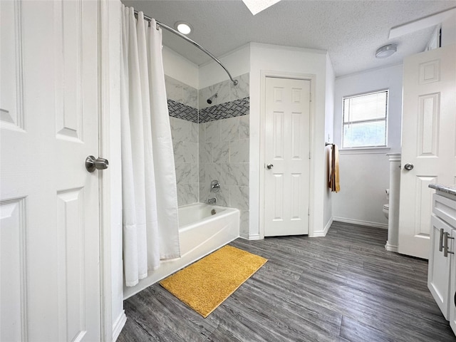 full bathroom featuring vanity, toilet, baseboards, wood finished floors, and shower / tub combo
