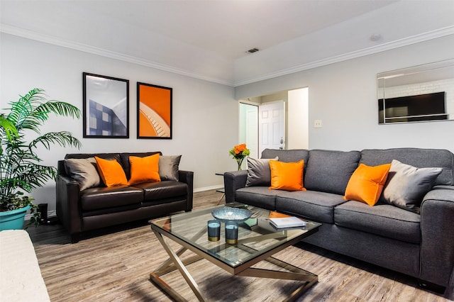 living area with ornamental molding, wood finished floors, and visible vents