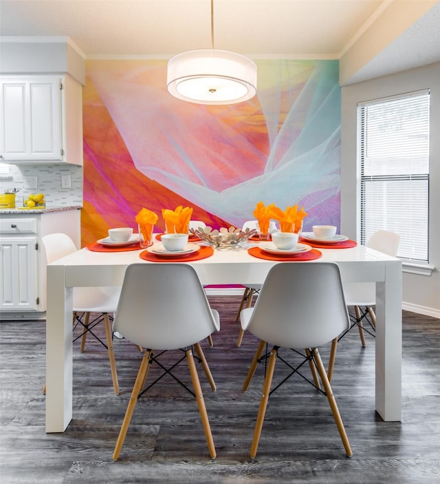 dining room with dark wood-style flooring, crown molding, and baseboards