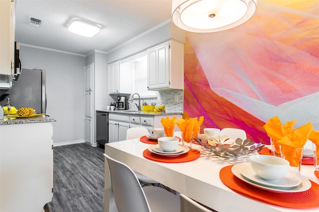 kitchen featuring crown molding, tasteful backsplash, visible vents, appliances with stainless steel finishes, and white cabinets