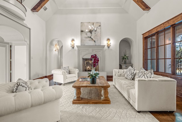 living area with a high ceiling, visible vents, and arched walkways