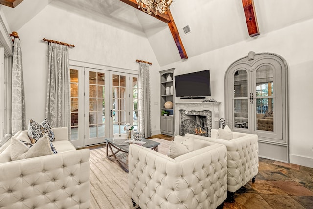 living area with stone tile floors, visible vents, high vaulted ceiling, a high end fireplace, and french doors