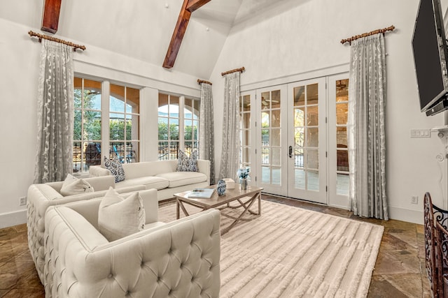 living room featuring stone tile flooring, french doors, high vaulted ceiling, and baseboards