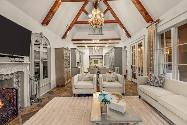 living room featuring beamed ceiling, a notable chandelier, high vaulted ceiling, stone tile floors, and a high end fireplace