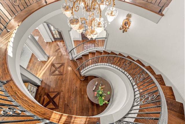 stairway featuring arched walkways and a chandelier