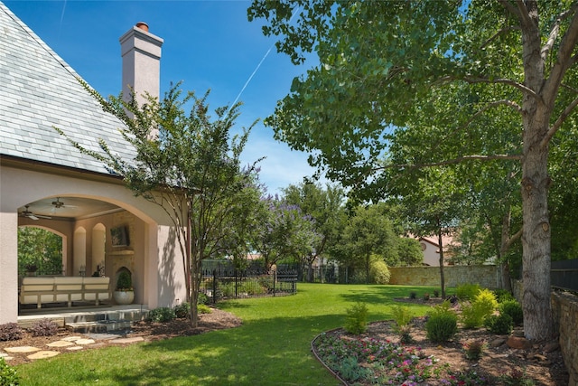 view of yard featuring a fenced backyard and ceiling fan