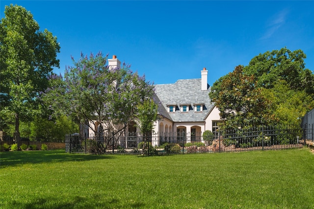 exterior space featuring a lawn, a chimney, and fence