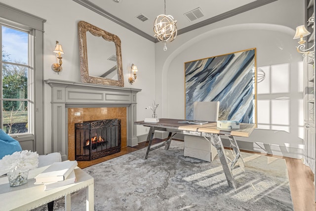 home office featuring crown molding, wood finished floors, visible vents, and a premium fireplace