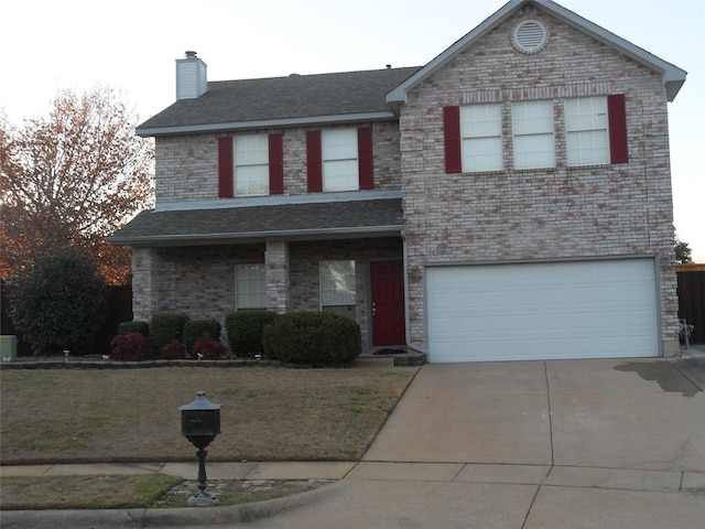 traditional-style home featuring a garage, concrete driveway, a front lawn, and brick siding