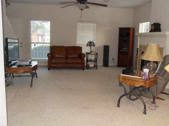 living area featuring carpet and a ceiling fan