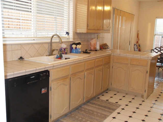 kitchen with tasteful backsplash, dishwasher, a peninsula, light floors, and a sink