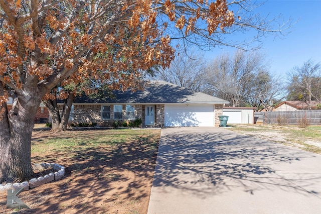 view of front of house with driveway, a garage, fence, and brick siding