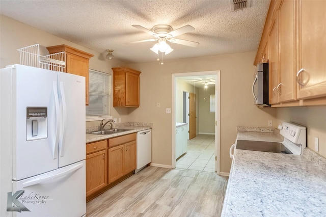 kitchen with light countertops, white appliances, visible vents, and a sink