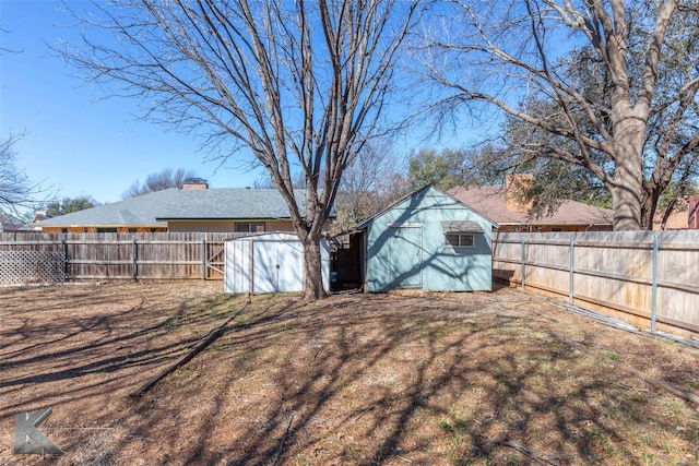 view of yard featuring an outbuilding, a storage unit, and a fenced backyard