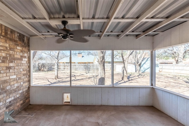 unfurnished sunroom featuring a ceiling fan