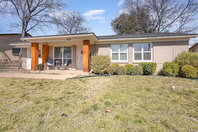 view of front of house featuring brick siding and a front yard