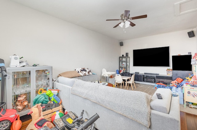 living area with a ceiling fan, attic access, and wood finished floors