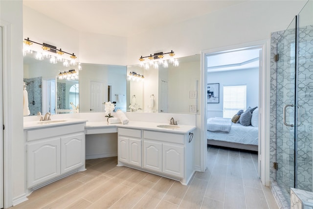 bathroom with a stall shower, double vanity, wood finished floors, and connected bathroom