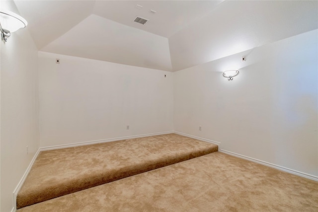 unfurnished room featuring carpet floors, lofted ceiling, and baseboards
