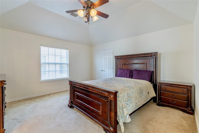 bedroom with light carpet, baseboards, a closet, lofted ceiling, and a ceiling fan