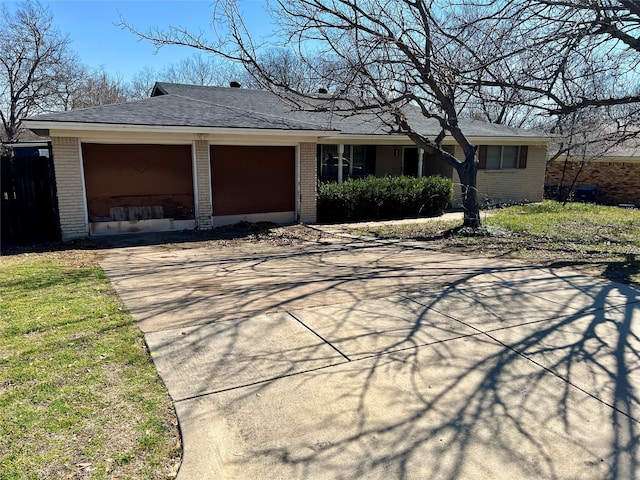 ranch-style house with driveway, an attached garage, roof with shingles, and brick siding