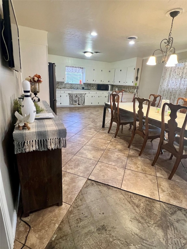 dining room with an inviting chandelier and light tile patterned floors