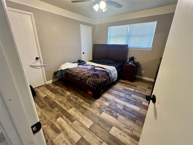 bedroom with ceiling fan, crown molding, baseboards, and wood finished floors