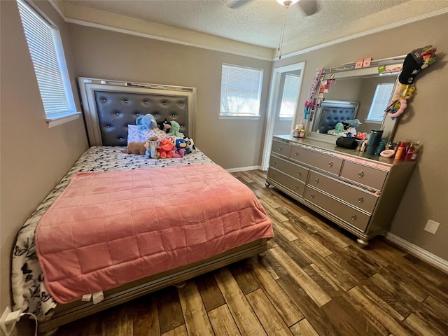 bedroom featuring a ceiling fan, a textured ceiling, baseboards, and wood finished floors