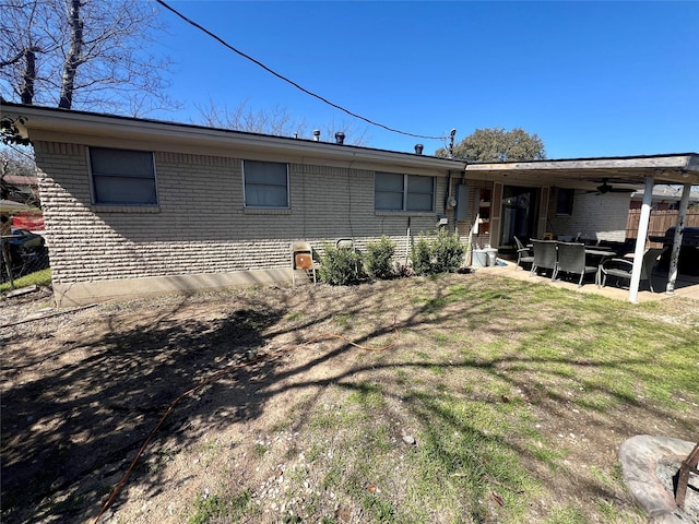 back of house with brick siding, a yard, a patio, a ceiling fan, and fence