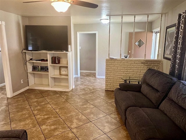 tiled living room featuring a ceiling fan and baseboards